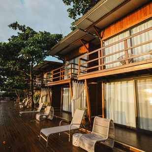 Vista aérea da Ilha do Mel Lodges com lodges sobre decks de madeira cercados pela natureza da Praia do Istmo.
