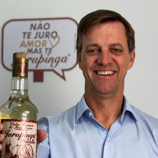 Garrafas de Jurupinga em destaque ao lado do logotipo da Zanlorenzi Bebidas, simbolizando a nova aquisição.