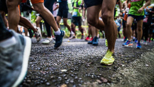Participantes de corrida de rua largando juntos, representando diversidade e inclusão no evento Correr é Positivo em Curitiba.