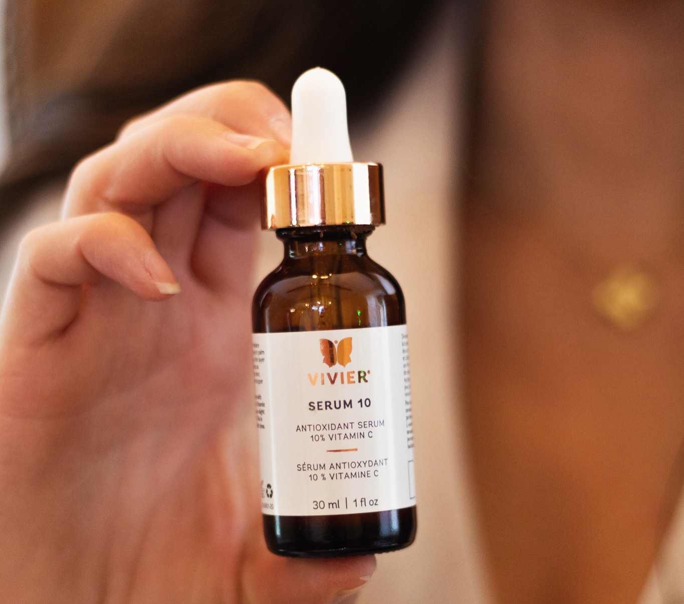 Close-up view of a vitamin C serum bottle beside fresh citrus slices.