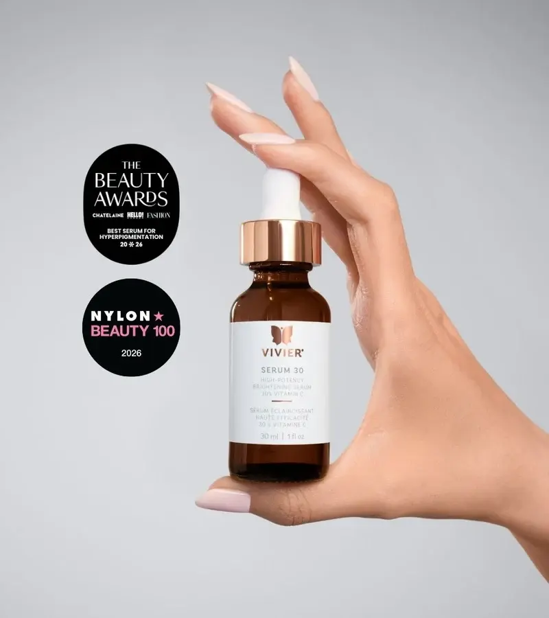Eye-level view of a simple skincare routine arranged on a stone bathroom counter.