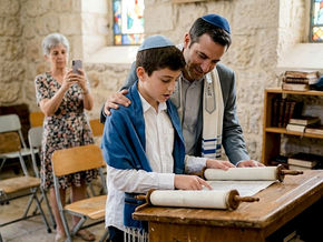 Boy reading Torah with family at synagogue