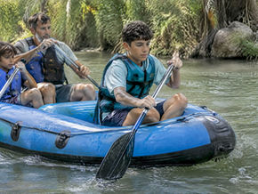 Teen paddling a family raft on the Jordan River