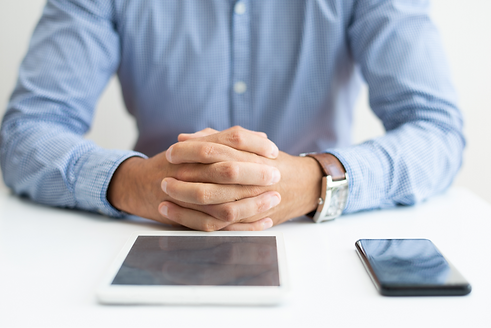 closeup-man-sitting-desk-with-tablet-smartphone_edited.png