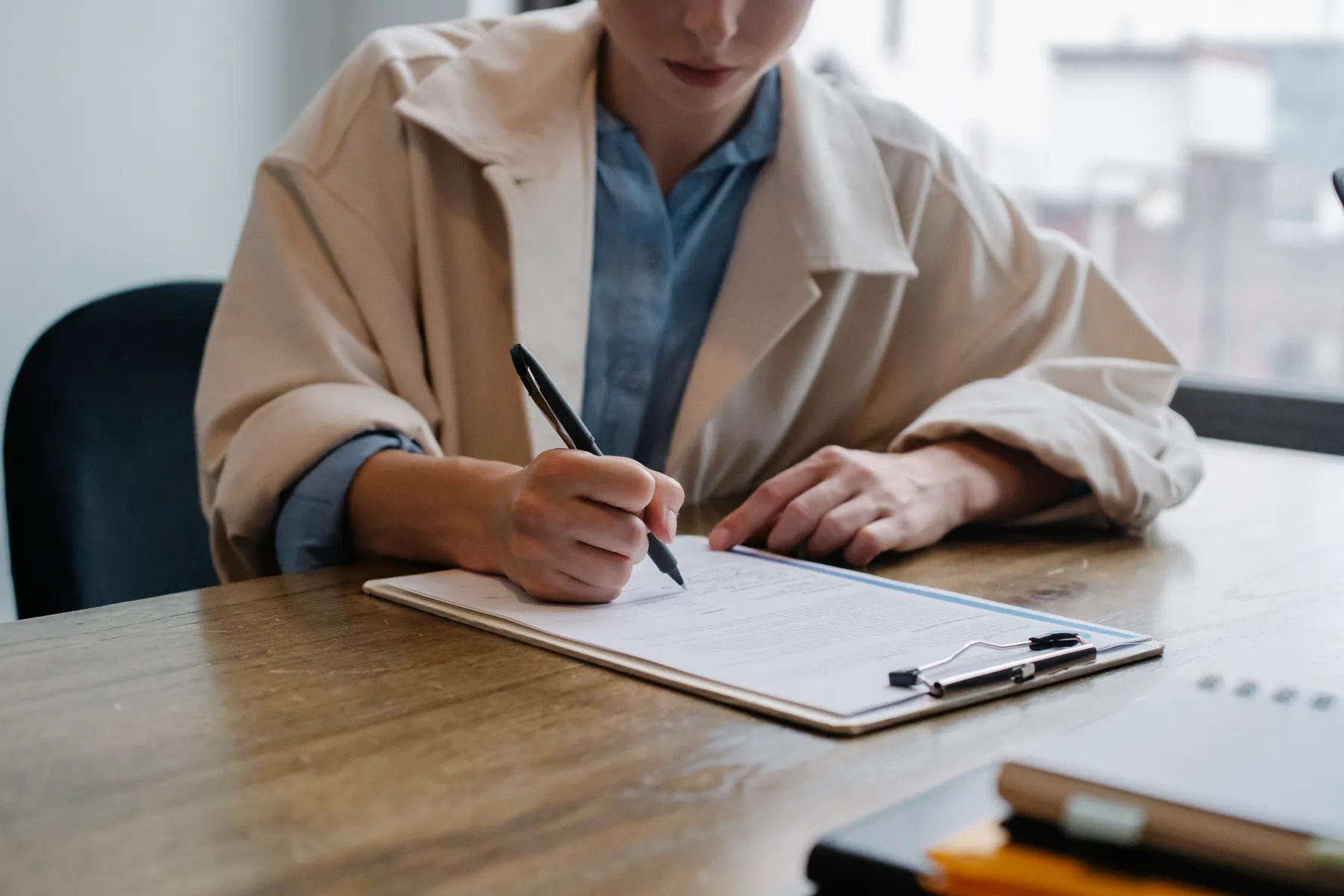A job applicant completes a form at a table.