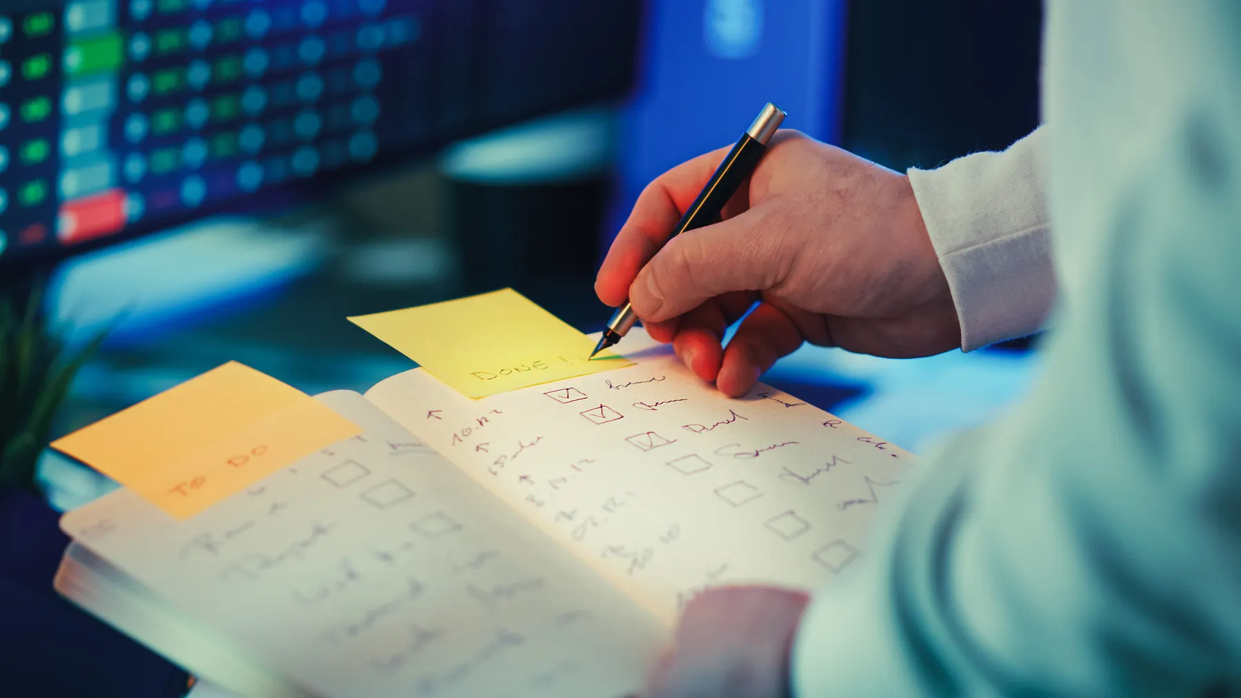 A person marks progress on a paper task checklist.