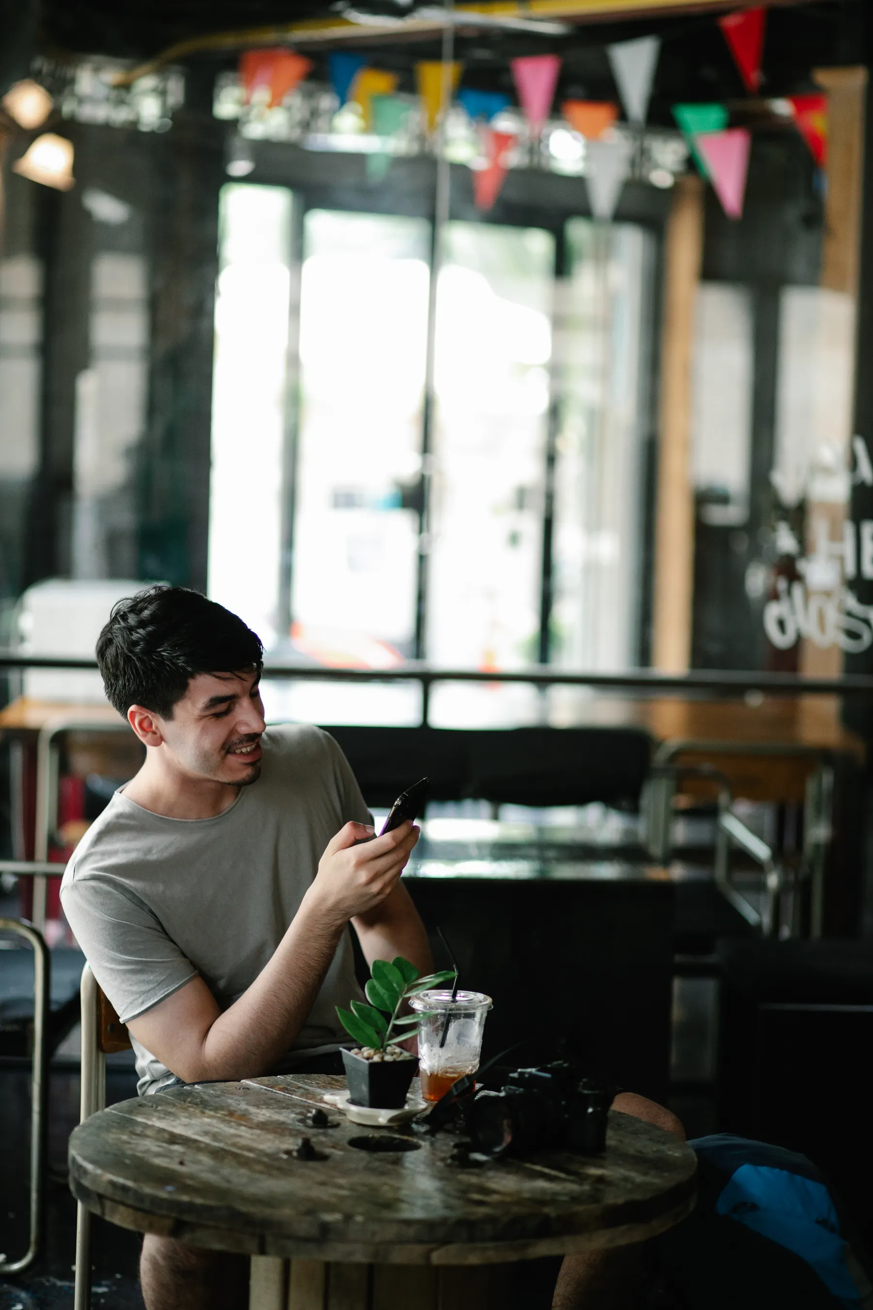 A person reads a phone at a café table.