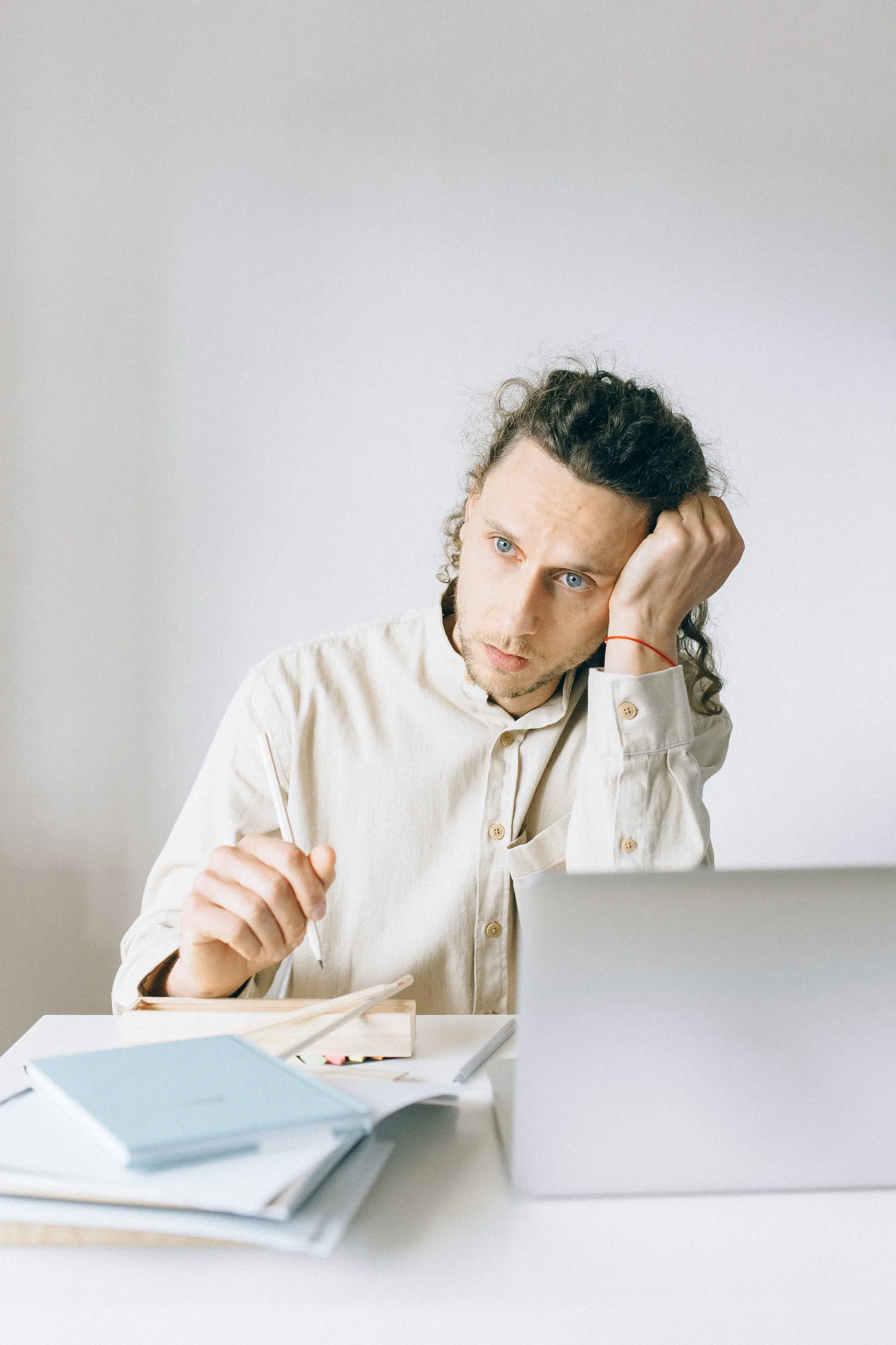 A person at a desk looks tired amid work documents.