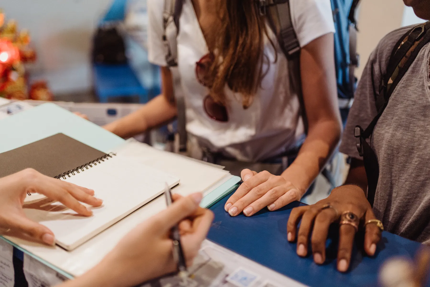 Students work together over notebooks at a shared table.
