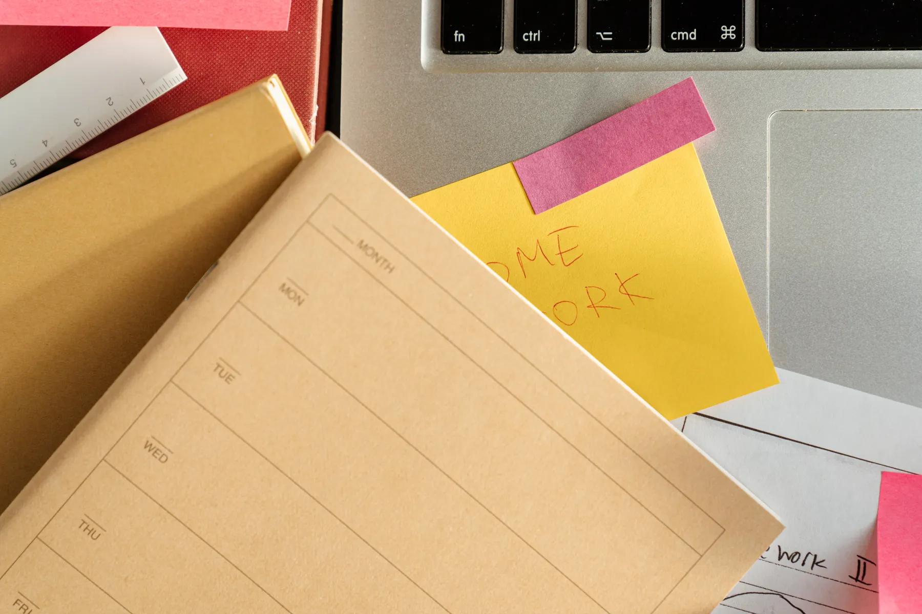 Study notes and colorful sticky notes surround a laptop.