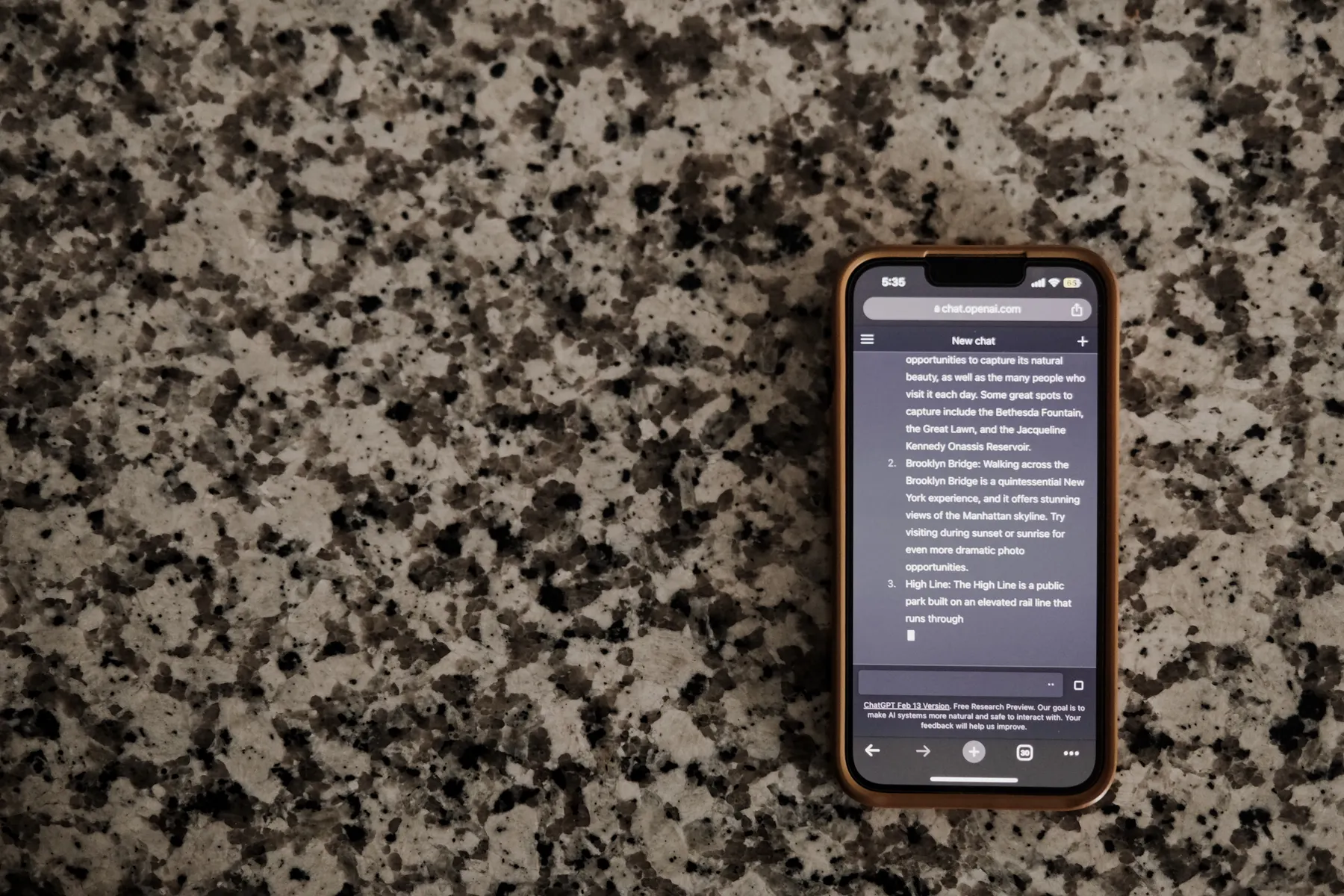A phone with a messaging screen rests on a countertop.