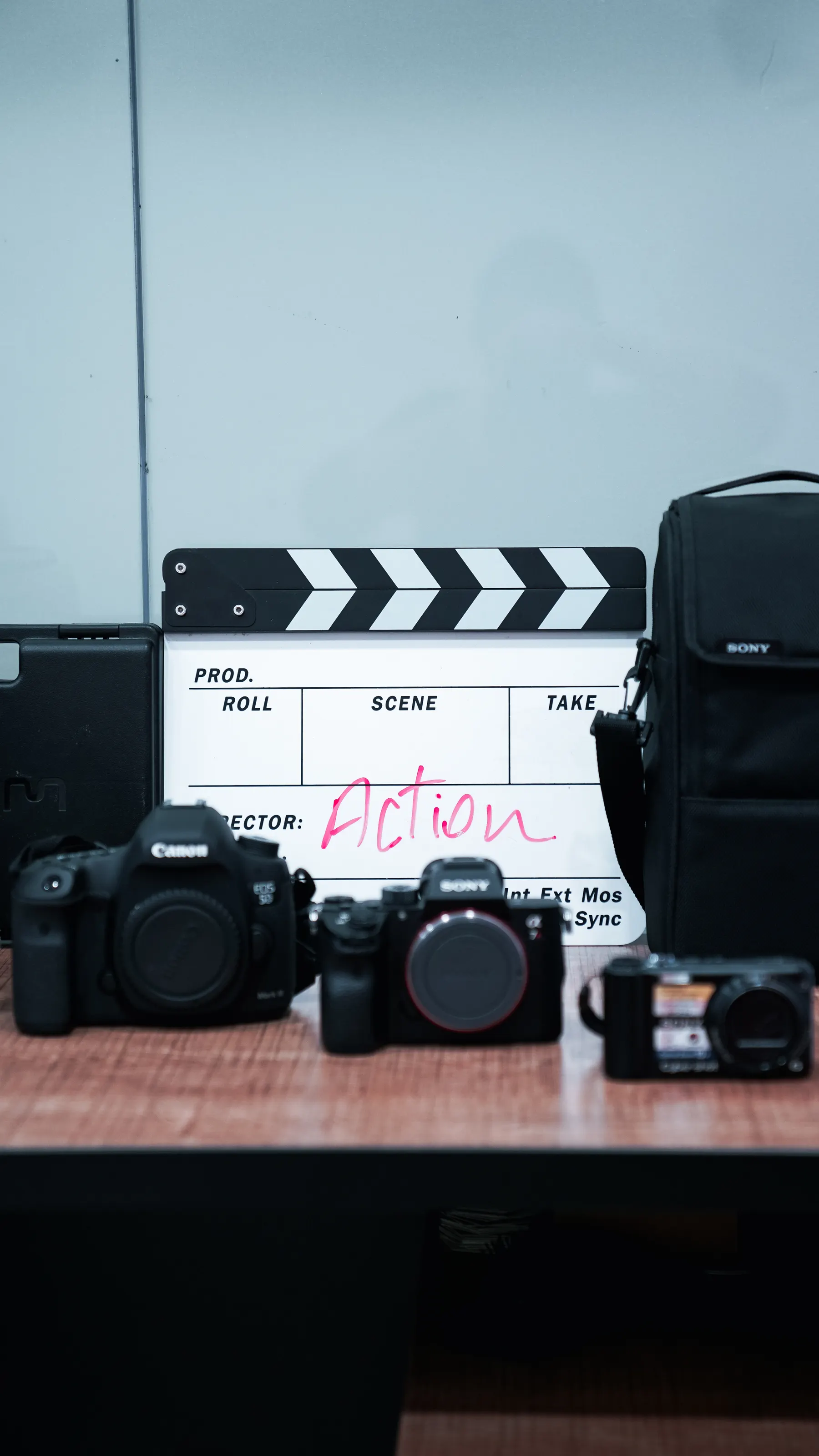 Film cameras and a clapperboard are arranged on a desk.
