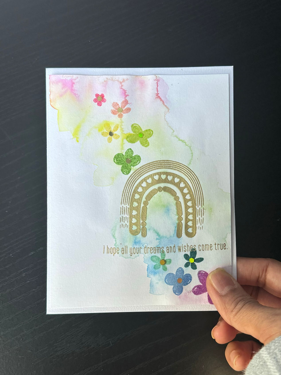 Card with gold heat embossed rainbow, watercolor washes, and stamped floral spray
