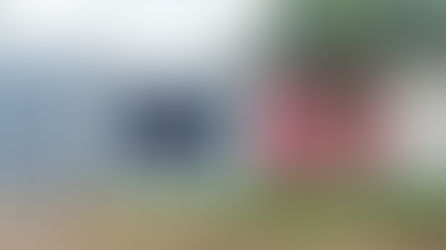 The lush, manicured garden at Fulgulab Lawns & Homestays, featuring vibrant flowering plants and greenery with a view of the Sahyadri mountains, perfect for a peaceful outdoor retreat