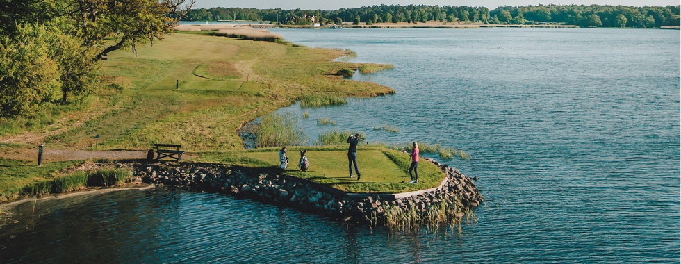 Person som spelar golf vid vattnet