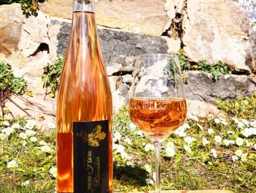En vinflaska och glas med vin i, rosé