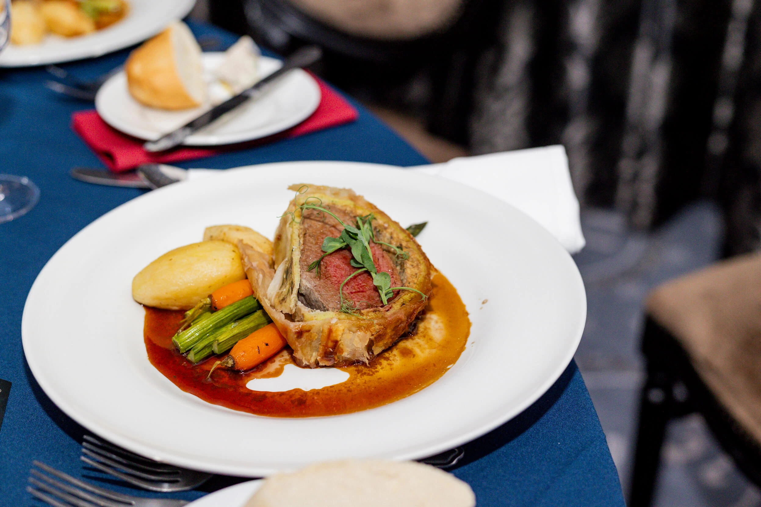 A plated meal featuring beef wellington and vegetables served during the party.