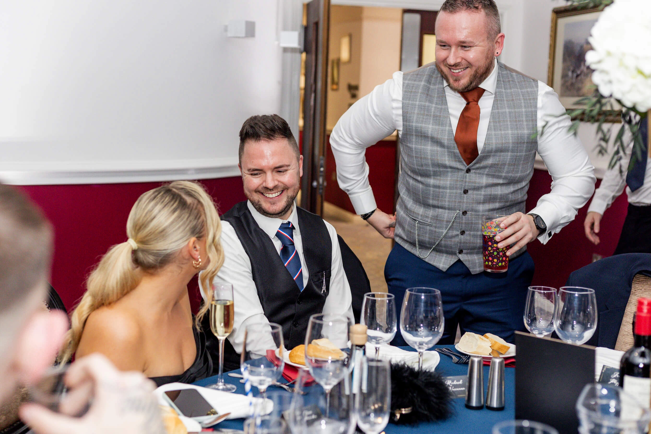 Guests seated at a dinner table, chatting and smiling during the formal dining part of the event.