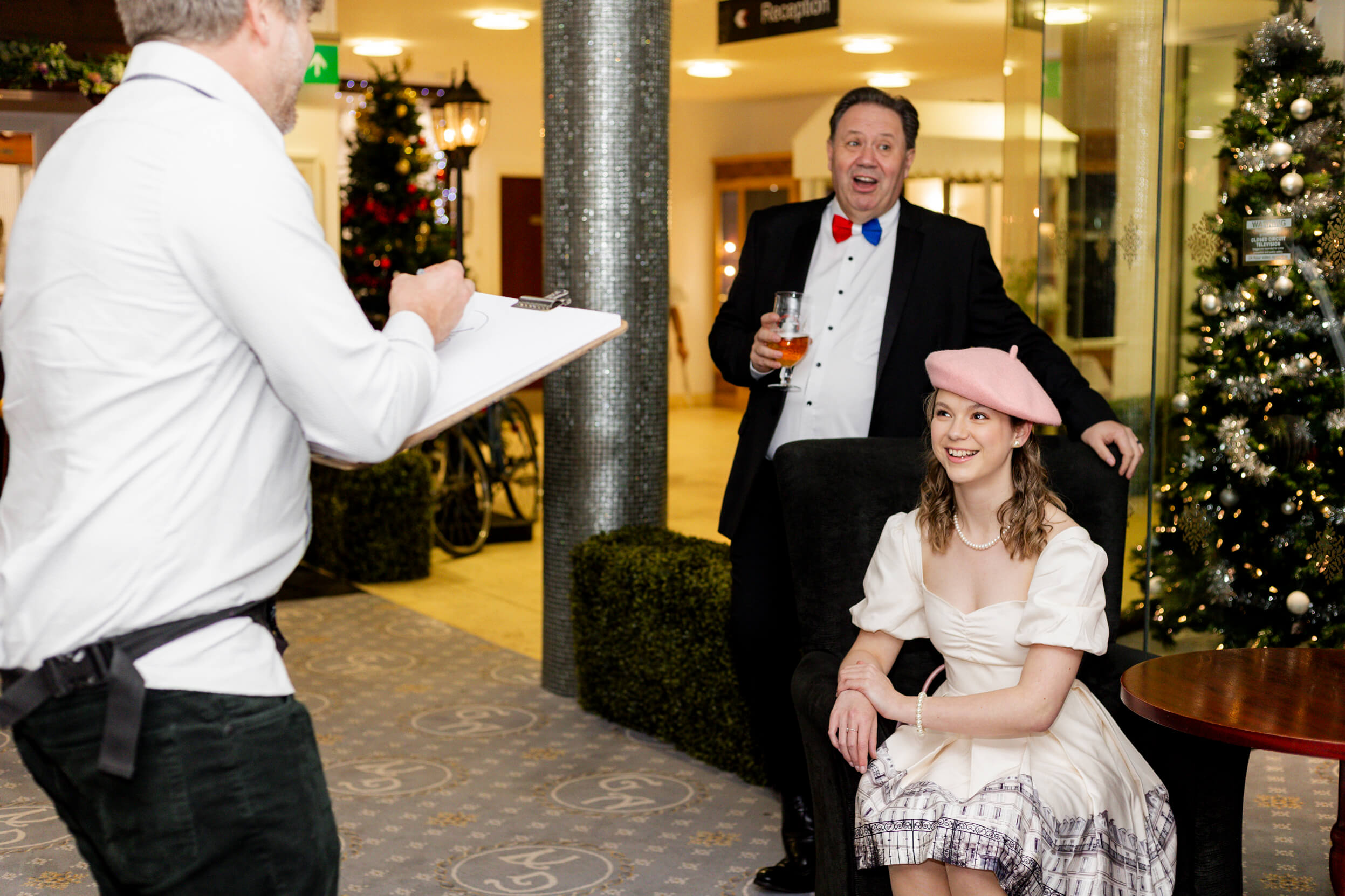 A caricature artist drawing guests, with festive decorations and a Christmas tree in the background.