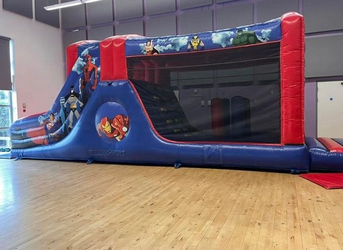 A Marvel superhero-themed bouncy castle with vibrant designs of iconic characters, creating an exciting play experience.