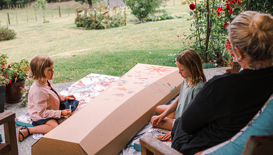 Family decorating a cardboard casket together