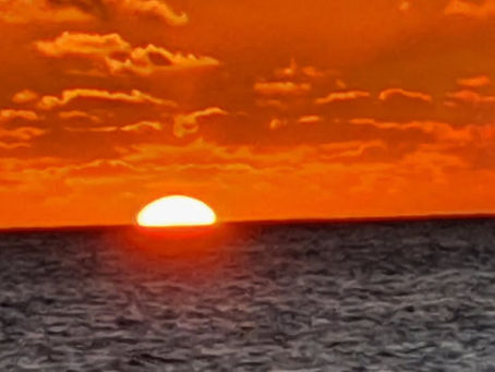 Sun setting in orange sky west of Ainse Vat beach, Noumea