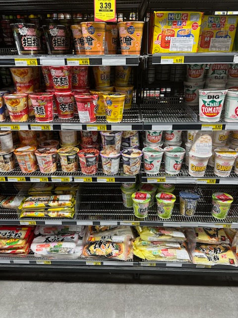 Shelf upon shelf of multi-coloured pot noodle cartons in Sydney convenience store