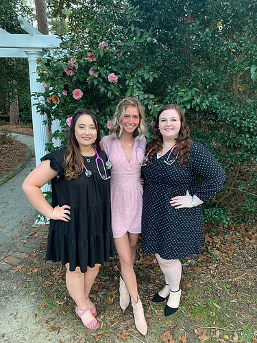 Students (from left to right) Madison Thum, Kathryn Bachman, and Autumn Thompson posing in formal wear with stethoscopes on.