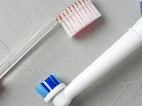 Manual and electric toothbrushes on a light background