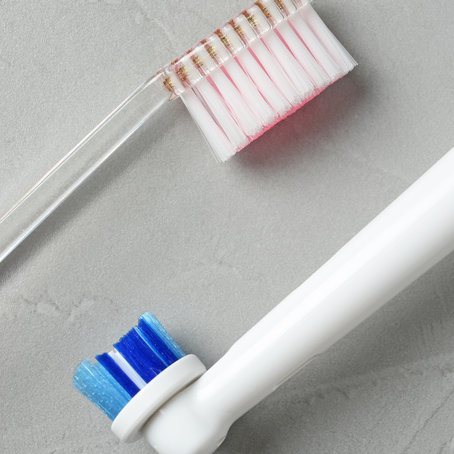 Manual and electric toothbrushes on a light background