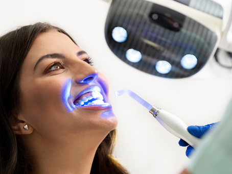 Woman receiving in-office teeth whitening treatment at a dental clinic