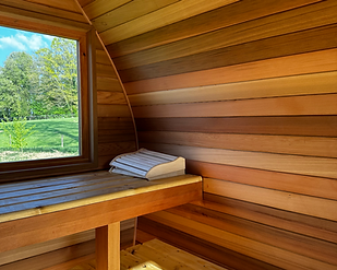 Intérieur d’un sauna en cèdre avec poêle à bois