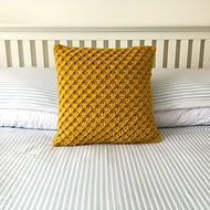 Star stitch cushion on bed.jpeg