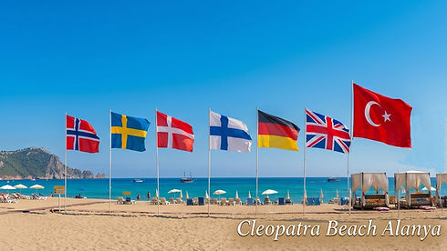 Cleopatra_beach_2026_show_the_castle_and_europe_flags_and_the_beach_with_travellers-hollid