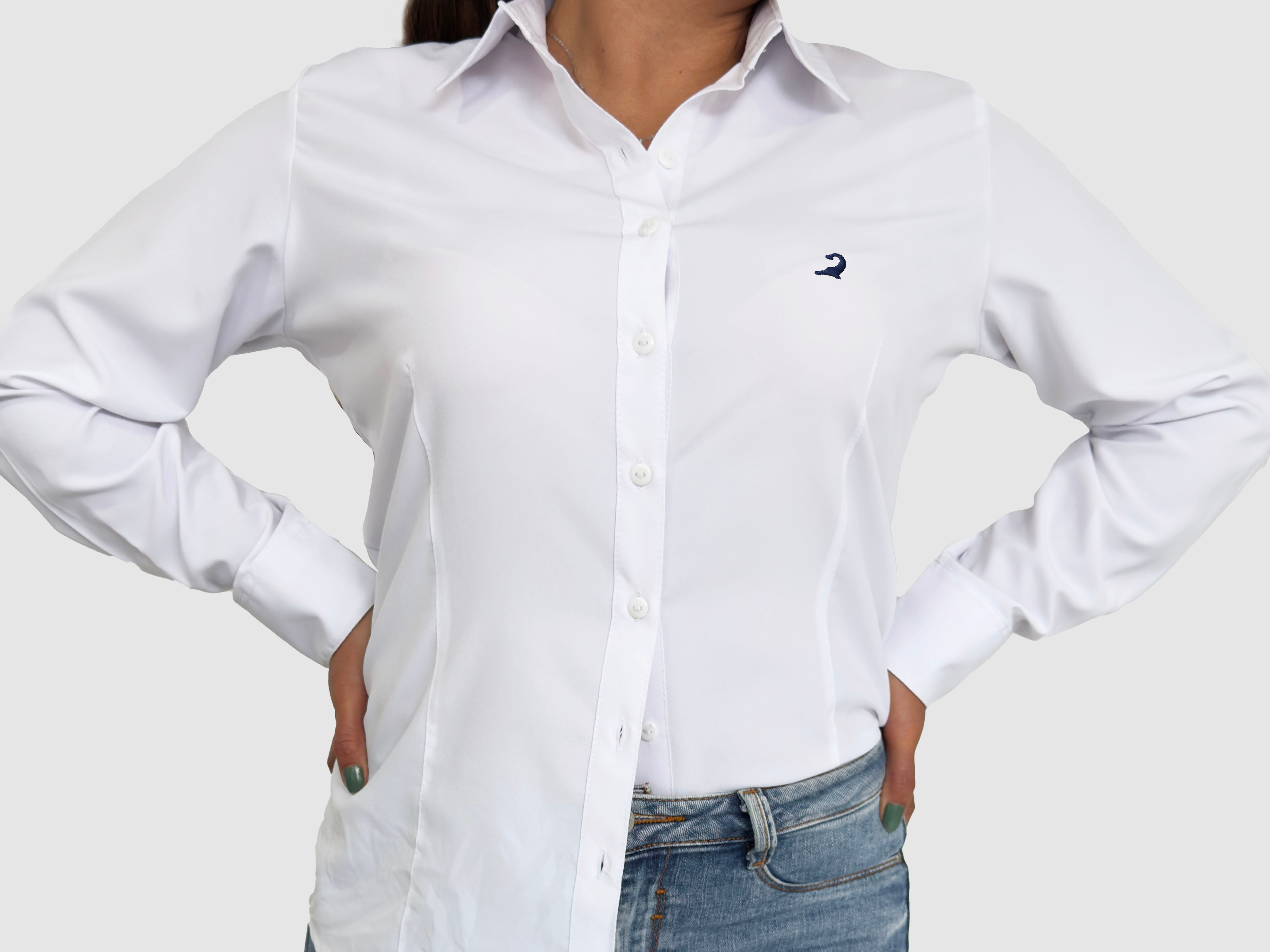 Mujer usando una camisa blanca de botones con bordado en forma de delfin baiji en azul con los brazos en sus costados con actitud rejalada