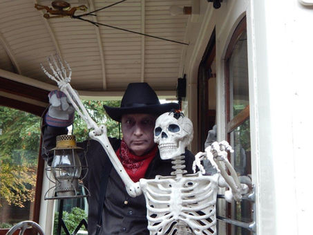 Issaquah History Museums volunteer Doug K. poses in costume with a skeleton aboard the Issaquah Valley Trolley.