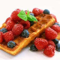 Golden brown waffles topped with fresh fruit.