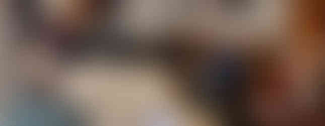 A group of 23 musicians sitting in a circle inside a church participating in a workshop