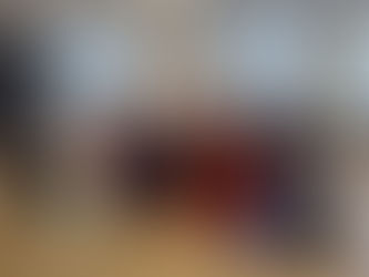 A large group of students wearing long 'bata de cola' skirts and holding fans pose together with teacher Aurora Caraballo