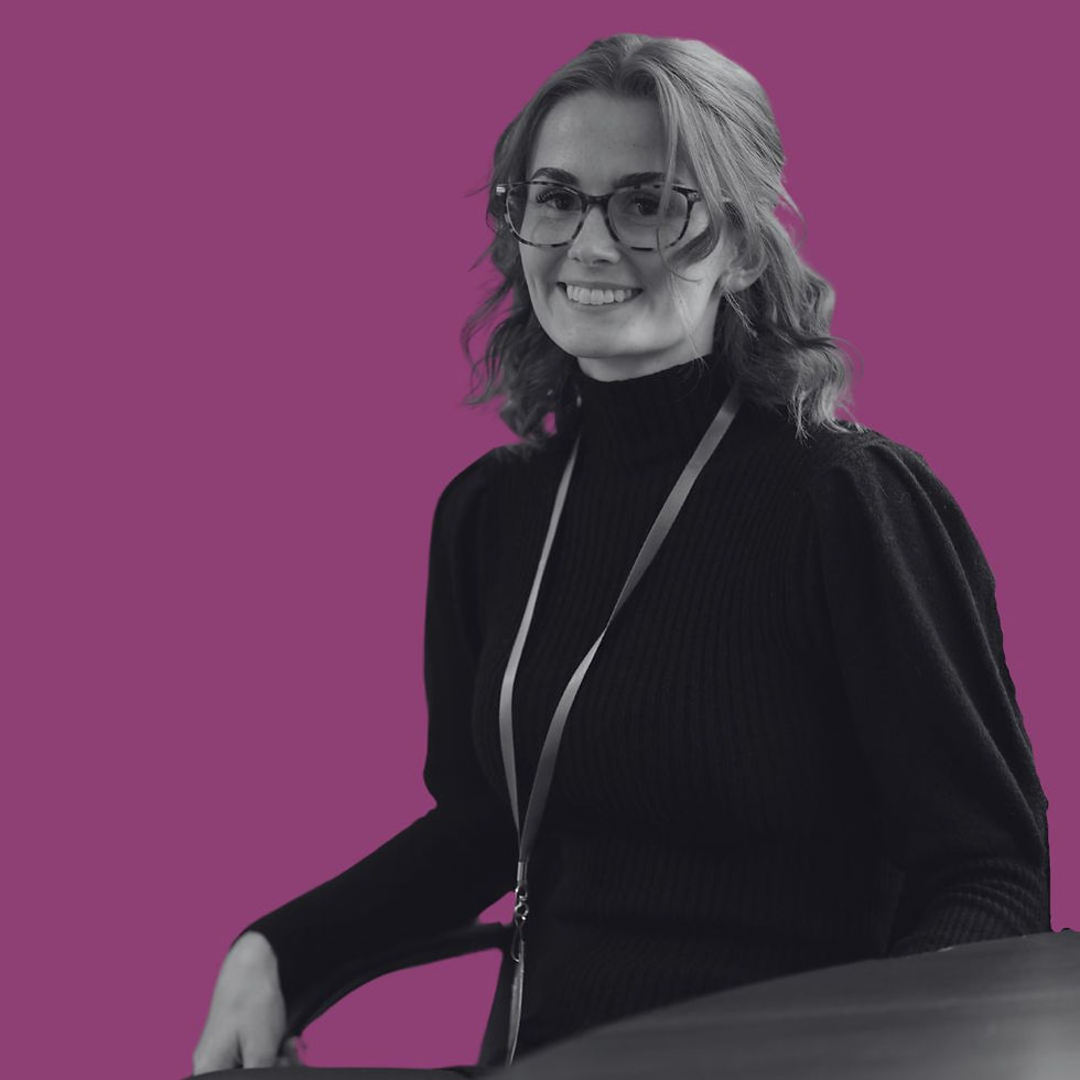 Black and white portrait of Amelia Papworth, Client Liaison Lead at Nellie Supports, seated and smiling in front of a branded purple background.