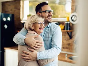 man and older woman (possible grandma) hugging and laughing