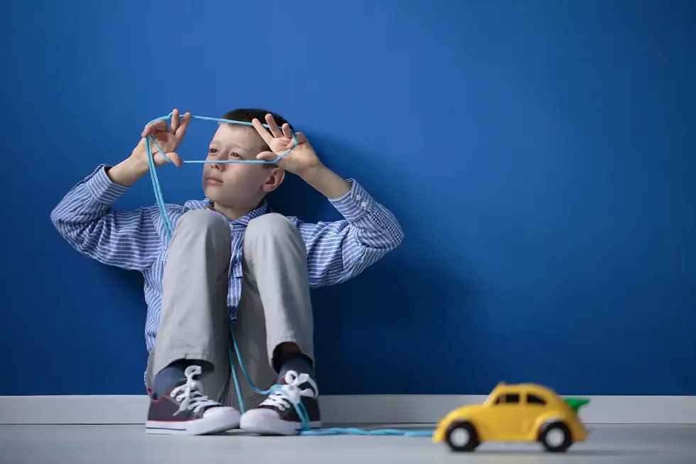 Young boy sitting thoughtfully with string in his hands, symbolising careful consideration of a child’s current abilities and future potential when assessing capacity