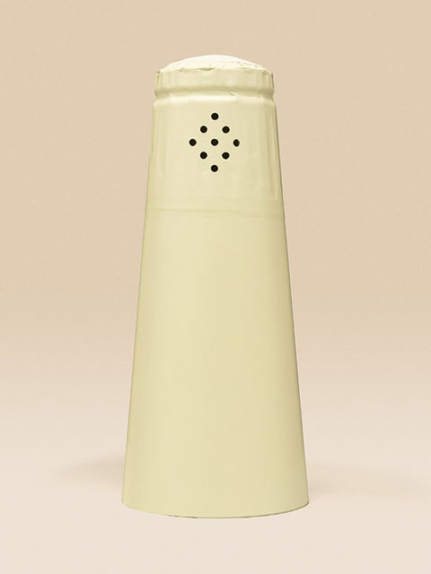 Eine cremefarbene Sektkapsel vor beigem Hintergrund