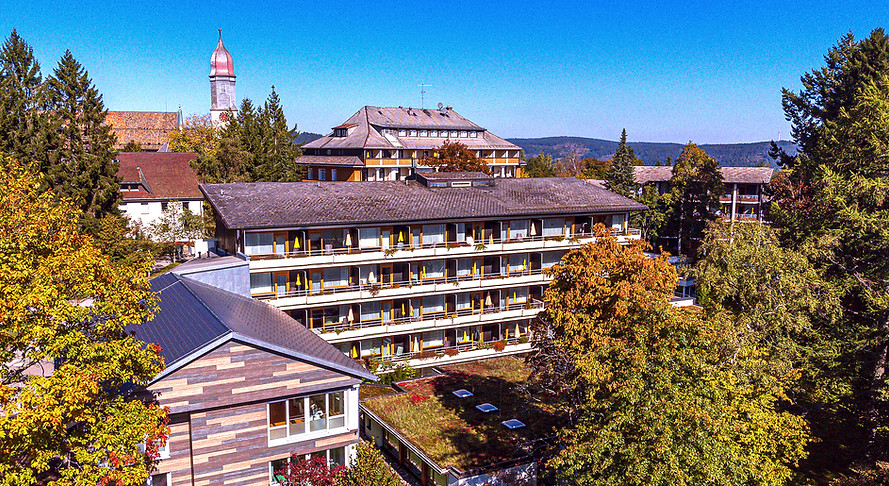 Außenansicht der Rehaklinik St. Georg im Schwarzwald mit umliegenden Bäumen und großem Hauptgebäude.