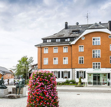 Frontalansicht der Rehaklinik St. Georg mit gepflegtem Vorgarten und klassischer Architektur.
