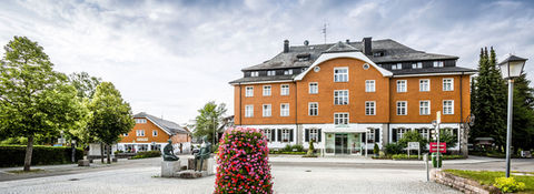 Frontalansicht der Rehaklinik St. Georg mit gepflegtem Vorgarten und klassischer Architektur.