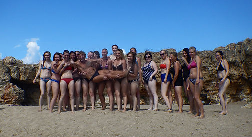 Girls holding man up on a beach