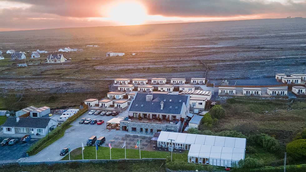 Aerial view of Inis Mór coastline with stone walls and green fields meeting the Atlantic waves.