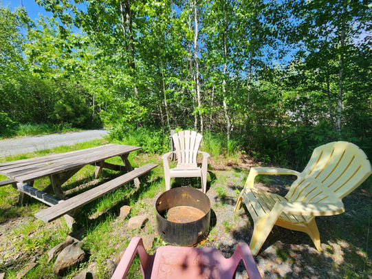 Outdoor fire pit with Adirondack chairs and picnic table