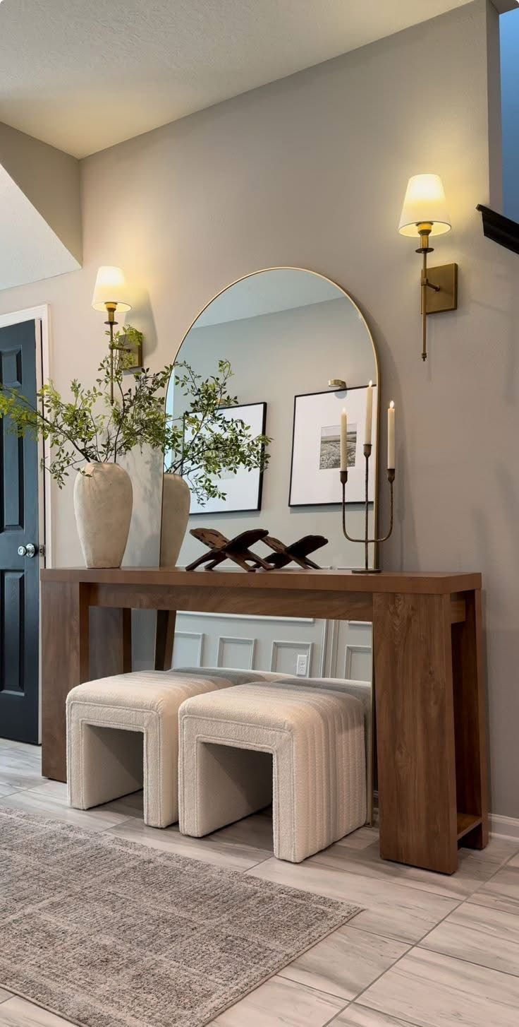 Residential console table styled with plants, artwork, and balanced decor